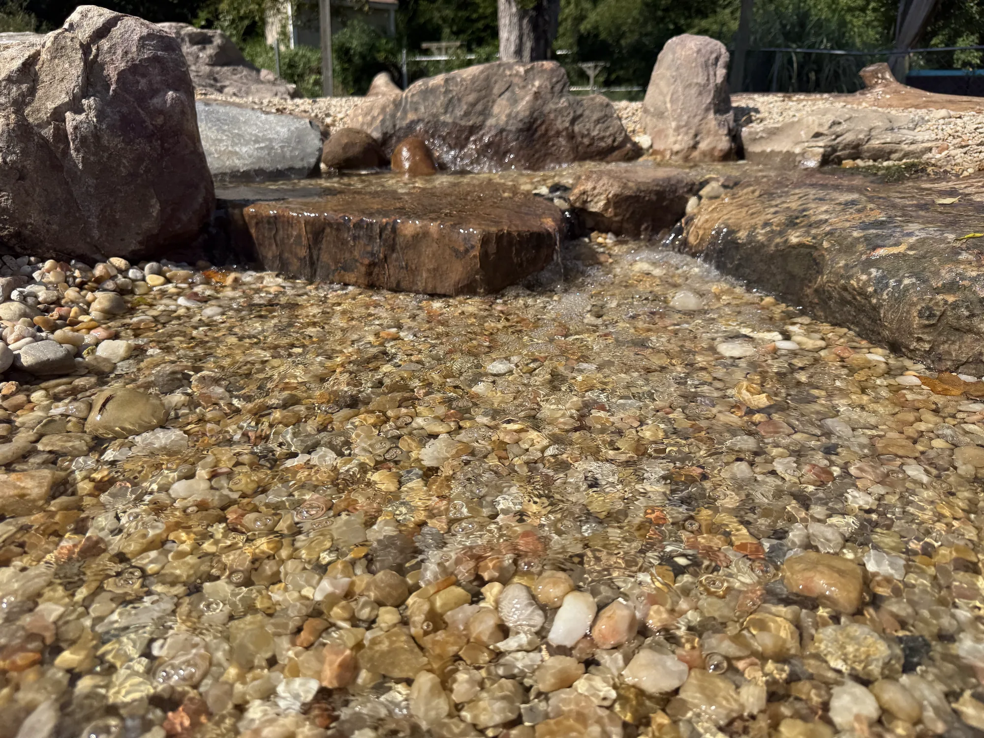 Boulders and washed gravel set in a new pond before the water goes in