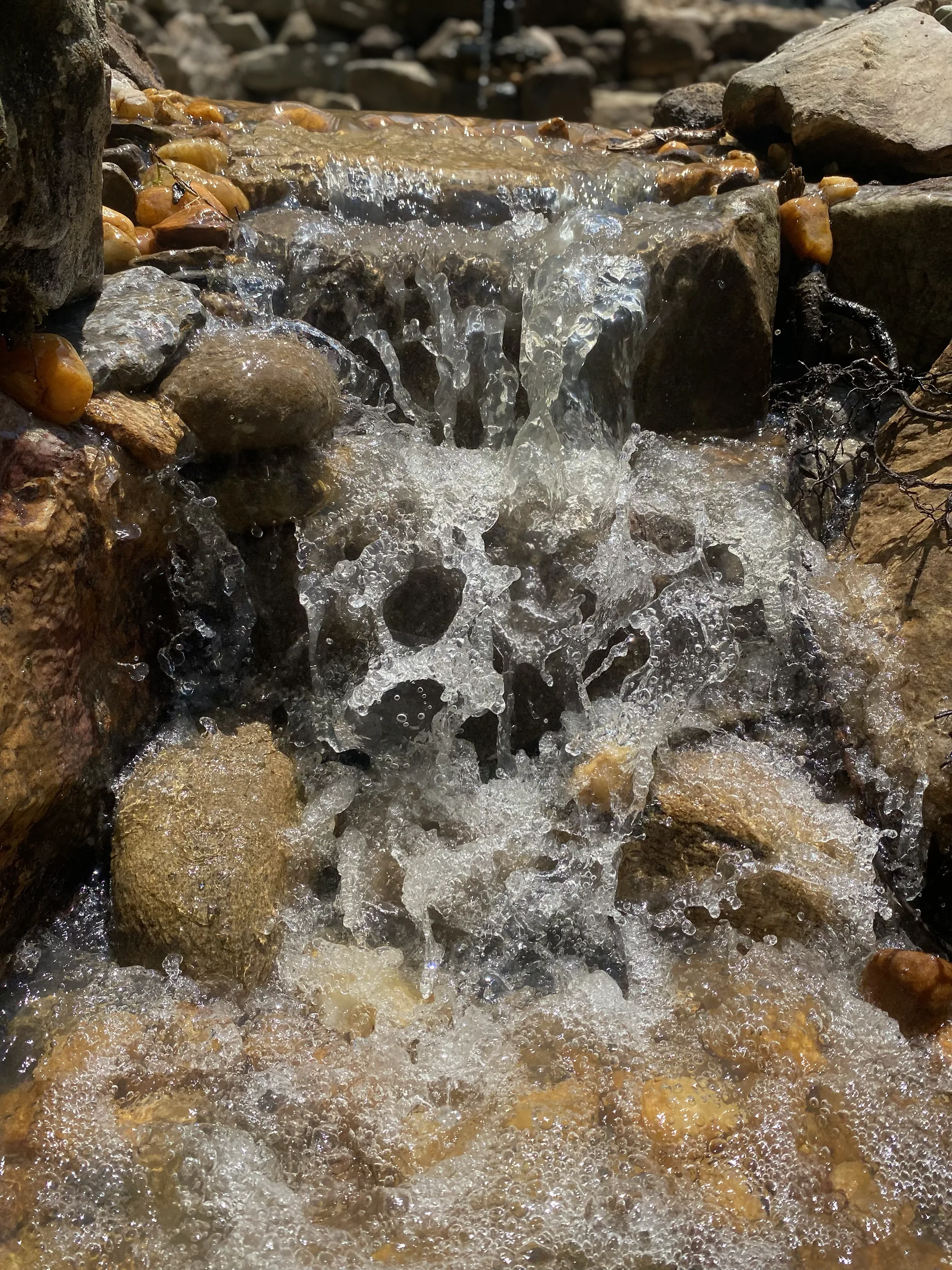 A tall waterfall crashing down a stack of rough boulders