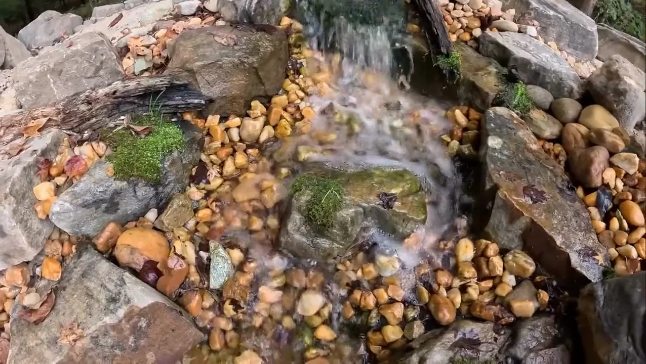 A pondless waterfall under construction, the stream bed shaped and lined