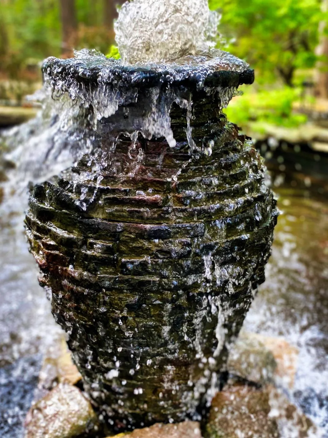 A stacked slate urn fountain with water running down its ridged sides